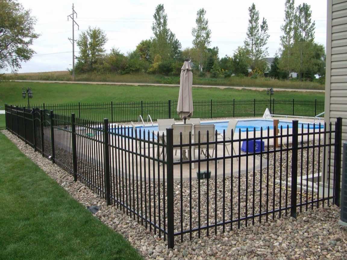 Black aluminum picket fence enclosing a pool and patio area